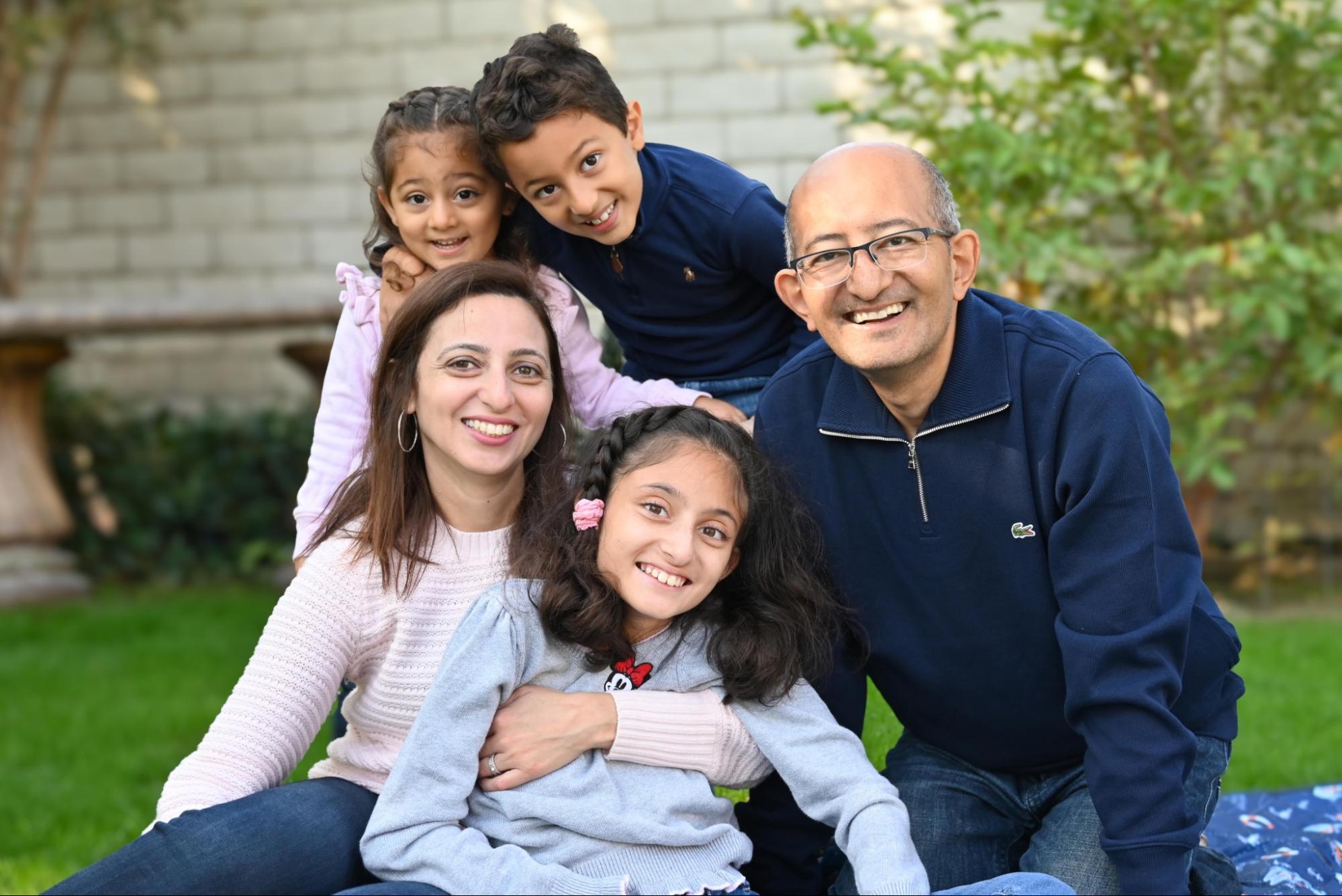 The family cluster together in the middle of the picnic blanket, almost like a pyramid.